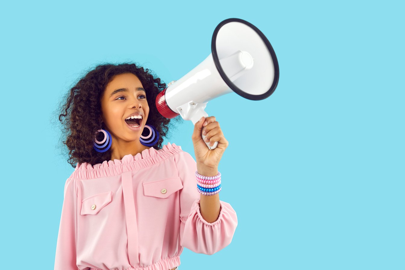 Happy Child Speaking through Megaphone and Making Loud Announcement about Fashion Sale